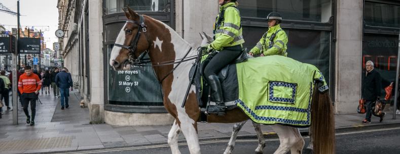 Police officers riding horses through a high street in Cardiff 