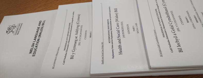 Fersiynau printiedig o Filiau’r Senedd wedi’u pentyrru ar ben bwrdd