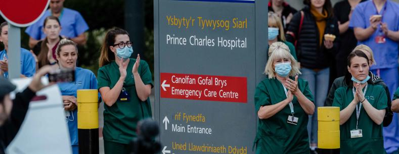 Staff o ysbyty'r Tywysog Siarl yn cymryd rhan yn y clap wythnosol i weithwyr allweddol yn ystod y pandemig