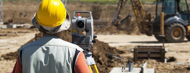 Llun o weithiwr adeiladu yn adeiladu ffordd.