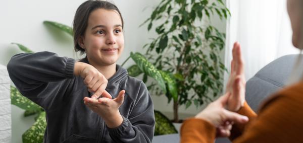 Delwedd o blentyn yn arwyddo gyda pherson arall