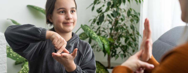 Delwedd o blentyn yn arwyddo gyda pherson arall