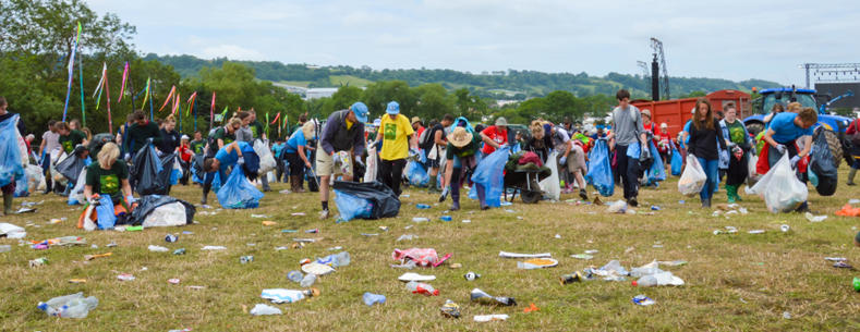 Canlyniad Gŵyl Glastonbury: criw o gasglwyr sbwriel ar y maes gwersylla. Mae'r ddelwedd yn dangos poteli gwag, caniau, a phebyll segur wedi'u gwasgaru ar draws y glaswellt.