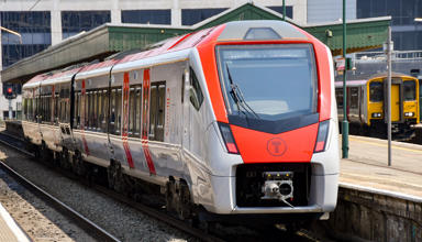 Trên Trafnidiaeth Cymru yn aros wrth blatfform gorsaf