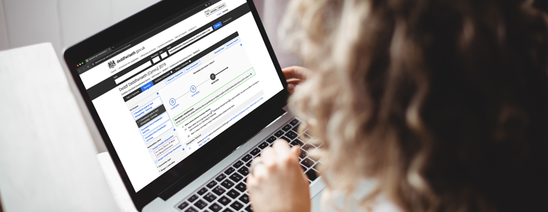 Person yn edrych ar wefan Legislation.gov ar liniadur.