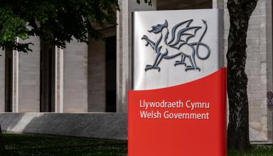 Dyma lun o logo Llywodraeth Cymru o flaen ei swyddfeydd ym Mharc Cathays.
