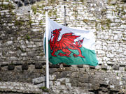 Ar y clawr mae llun o faner draig goch Cymru yn cyhwfan o flaen wal castell.