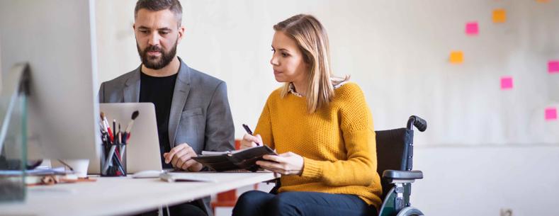 Defnyddiwr cadair olwyn yn y gwaith