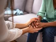 Person yn dal llaw person arall