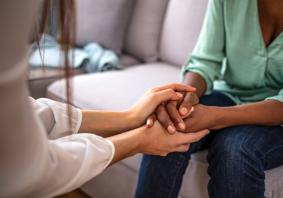 Person yn dal llaw person arall