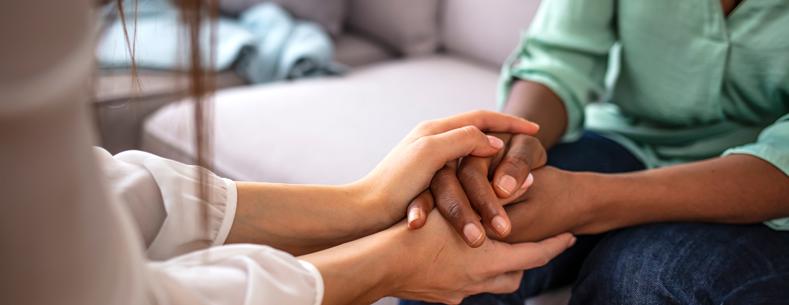 Person yn dal llaw person arall