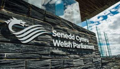 Arwydd Senedd Cymru - Welsh Parliament y tu allan i adeilad y Senedd