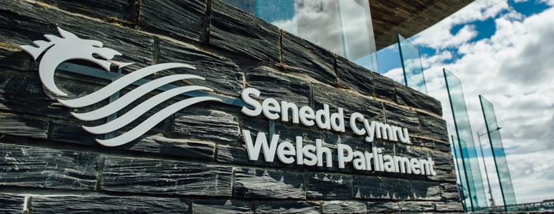 Arwydd Senedd Cymru - Welsh Parliament y tu allan i adeilad y Senedd