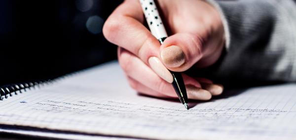 Dyma lun o blentyn yn ysgrifennu ar bapur, sy'n awgrymu ei fod yn gwneud gwaith ysgol.