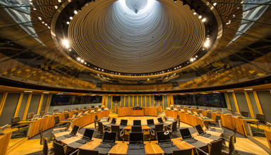 Siambr y Senedd o'r tu mewn yn edrych i fyny at y golau y tu allan.