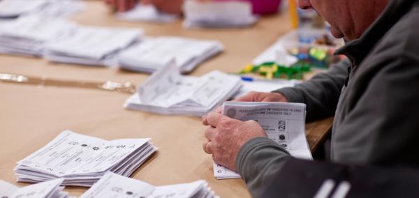 Delwedd o rywun yn cyfrif pleidleisiau mewn etholiad Senedd. 