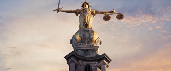 The statue of Lady Justice, holding a sword and scales in either hand, above the Old Bailey court in London 