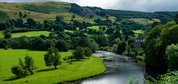 Image of river bend in a Welsh farming landscape, with hilltop quarry in the distance.